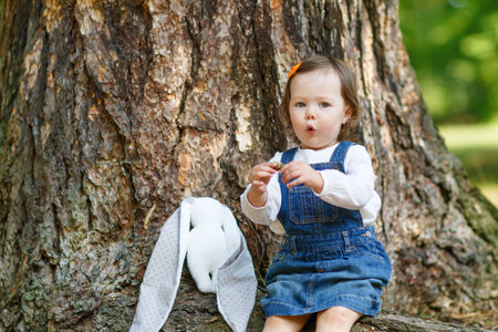Little cute baby girl having fun in summer parkの写真素材