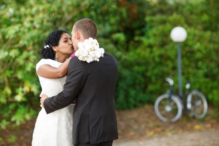 Beautiful indian bride and caucasian groom, in summer parkの写真素材