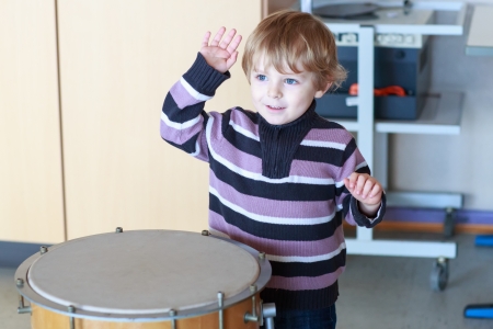 Little toddler boy playing drum at music schoolの写真素材