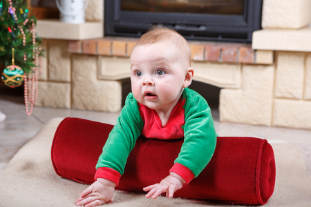Adorable baby boy in santa clothes with christmas decorationの写真素材