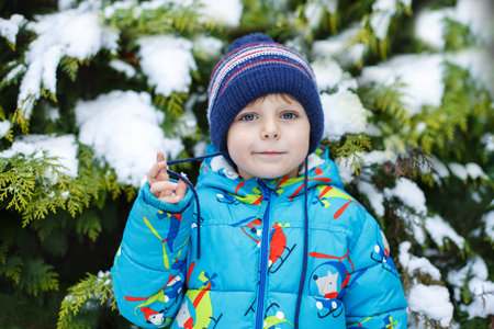 Portrait of little toddler boy three years old in winter with snowy background
