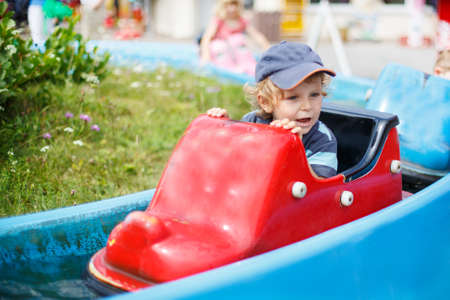 cute boy of two years having fun on water attraction in amusement parkの写真素材