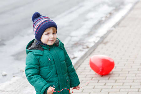 Portrait of little boy of two years in warm clothes outdoorの写真素材