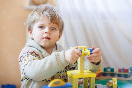 Little toddler boy playing with wooden toy, indoors.の写真素材