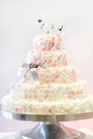 Delicious beautiful wedding cake in white , creme and pink.の写真素材