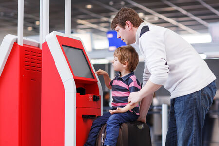Happy family of two: Father and little son at the international airport, traveling together and checking in at terminal.の写真素材