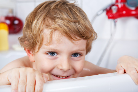 Portrait of lovely little toddler boy  having fun by taking bath in bathtub.の写真素材
