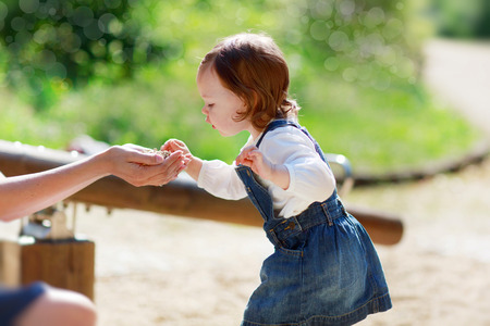 Little cute baby girl on playground in summer park, outdoors.の写真素材