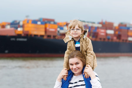 Little son and his mother watching ships on a ferry