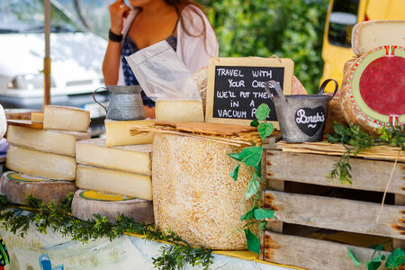 Selling and buying cheese  on market place in Provence, France. Hands of a sellerの写真素材