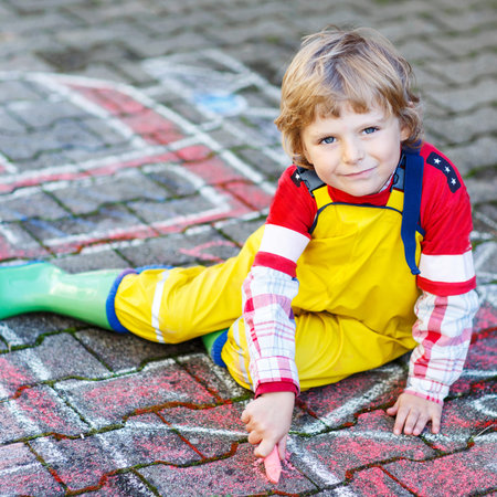 Creative leisure for kids: adorable child clothing as fireman having fun with fire truck picture...