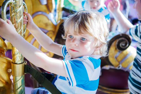 Little cute boy during carousel ride, enjoying and having fun.の写真素材