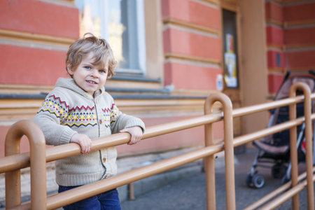 Little caucasian toddler boy of two years having fun in spring city, outdoorsの写真素材