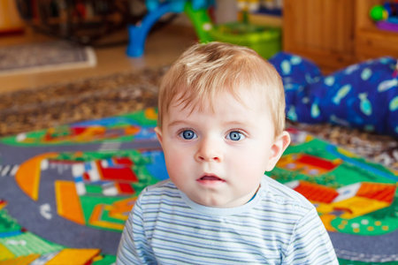 Beautiful little baby boy playing with different toys indoors. Home, nursery or kindergarten.の写真素材