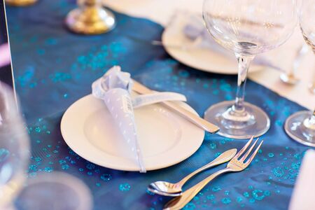 Beautiful elegant table set  for wedding or event party in blue and white with flowers, indoorsの写真素材