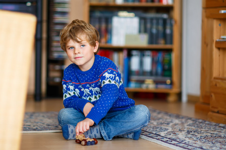 Little kid boy playing with handmade chestnut toy indoors. Happy funny child having fun with creation of handcraft thing. Creative leisure for kids in kingergarten or nursery or preschool.の写真素材