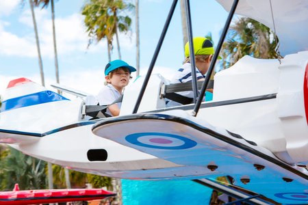 Two little funny kid boys riding on roundabout carouselの写真素材