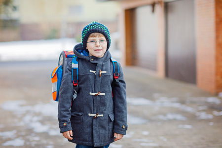 Little school kid boy of elementary class walking to school.の写真素材