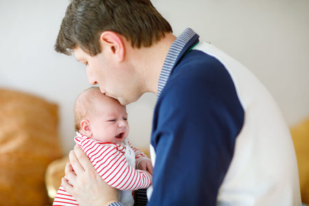 Happy proud young father with newborn baby daughter, family portrait togehter