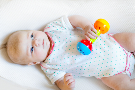 Cute baby girl playing with colorful rattle toysの写真素材