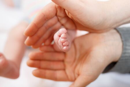 Father or mother holding foot of newborn babyの写真素材
