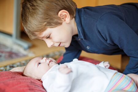 Happy little kid boy with newborn baby sister girlの写真素材