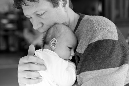 Happy proud young father with newborn baby daughter, family portrait togehterの写真素材