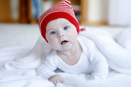 Cute adorable baby child with Christmas winter cap on white backgroundの写真素材