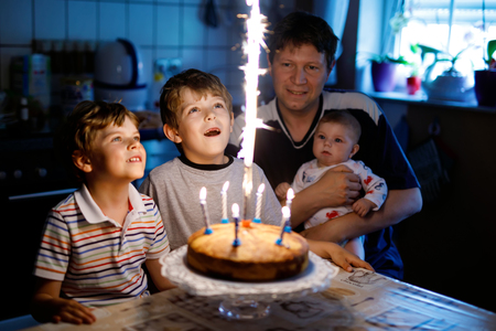 Little kid boy and family, father, brother and baby sister celebrating birthdayの写真素材