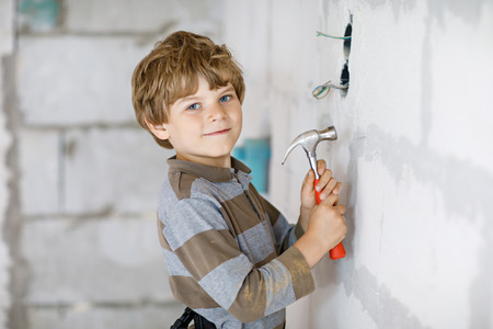 Little kid boy helping with toy tools on construciton site.の写真素材