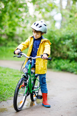 Cute little preschool kid boy riding on bicycle in park.の写真素材