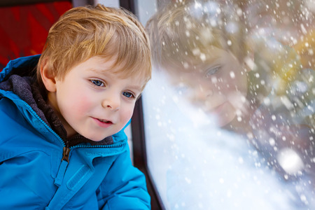 Cute little toddler boy looking out train windowの写真素材