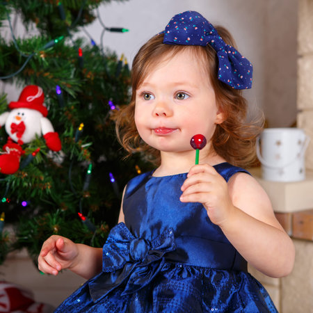 Adorable little kid girl celebrating Christmas holiday at homeの写真素材