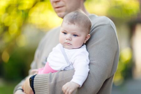 Happy proud young father with newborn baby daughter, family portrait togehterの写真素材