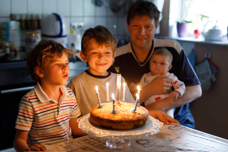 Little kid boy and family, father, brother and baby sister celebrating birthday