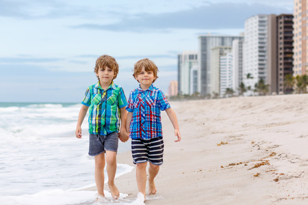Two little kids boys running on the beach of oceanの写真素材