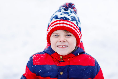 Cute little kid boy in winter clothes outdoors