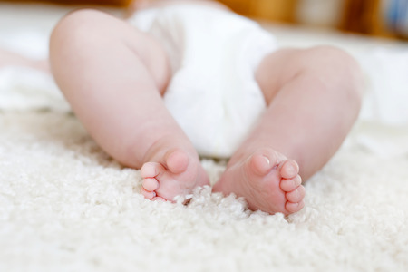 Feet and legs of newborn baby with diaper. Cute little girl or boy two months old Dry and healthy body and skin concept. Baby nurseryの写真素材