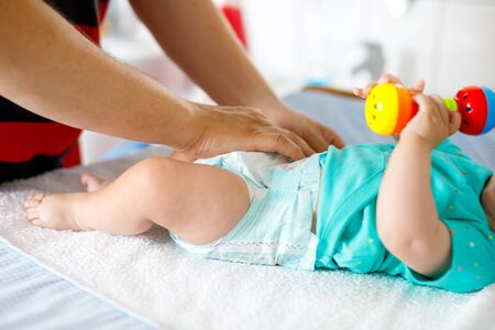 Close-up of father changing diaper of his newborn baby daughter.の写真素材
