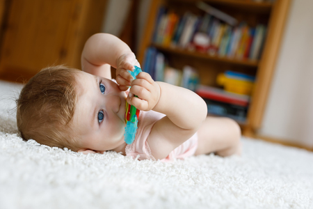 Adorable baby girl playing with educational toys in nurseryの写真素材