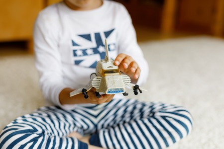 Happy little kid boy playing with space shuttle toy. Closeup of hands with old toyの写真素材