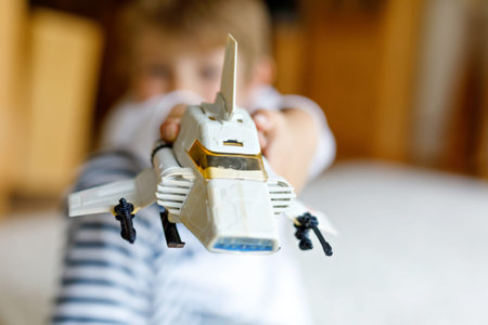 Happy little kid boy playing with space shuttle toy.の写真素材