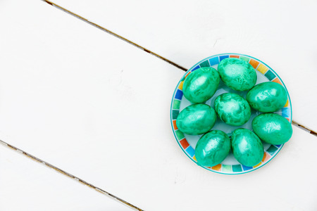 Easter eggs on wooden background. Colorful eggs in different colors - red, yellow, orange, purple and green.の写真素材