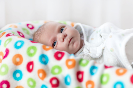 Cute little newborn baby girl wrapped in blanketの写真素材