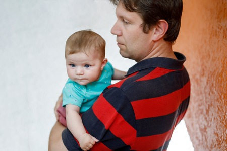 Happy proud young father with newborn baby daughter, family portrait togehterの写真素材
