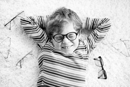 Close-up portrait of little blond kid boy with brown eyeglassesの写真素材