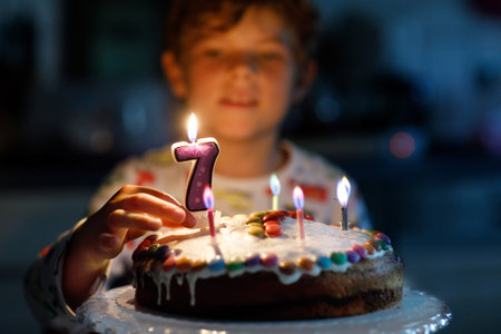 Adorable happy blond little kid boy celebrating his 7 birthday.