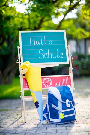 School beginning concept. Satchel and schoolbag, backpack, desk and traditional German school cone with gifts called Schultuete in Germanyの写真素材