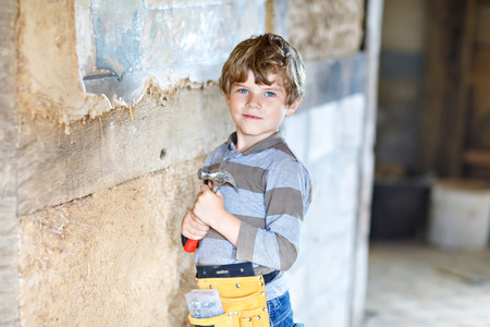 Little kid boy helping with toy tools on construciton site.の写真素材
