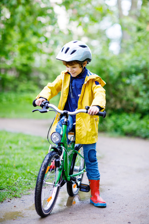 Cute little preschool kid boy riding on bicycle in park.の写真素材